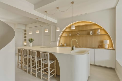 Cuisine moderne aux Suites Du Port à Arcachon avec îlot courbe, étagères en bois arquées et luminaires suspendus