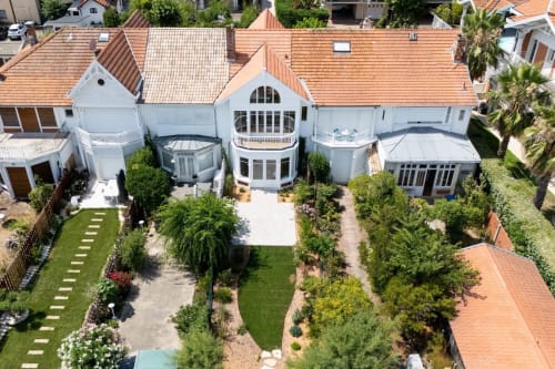 Vue aérienne de l'hôtel Les Suites Du Port à Arcachon avec architecture blanche, toits en terre cuite et jardins luxuriants