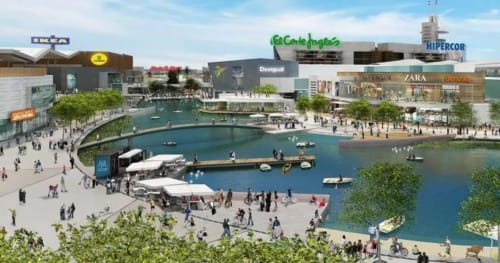 Moderno desarrollo de plaza frente al agua en Zaragoza con tiendas, canal, barcos y peatones
