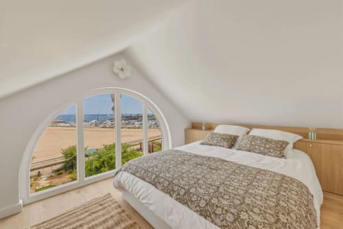 Chambre lumineuse mansardée avec fenêtre cintrée sur la plage aux Suites Du Port, Arcachon