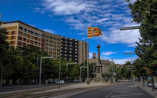 Plaza de Zaragoza con monumento histórico, edificios modernos y bandera aragonesa cerca del Hostal Zaragoza Centro