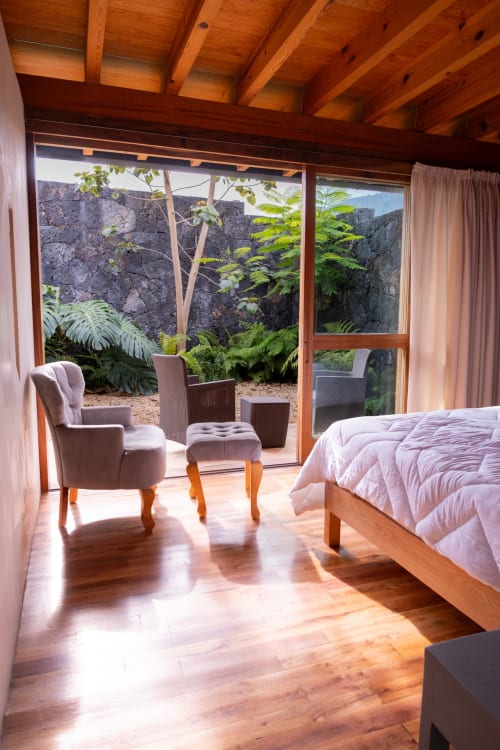 Luxurious bedroom at La Hacienda Tepoztlan with wooden beams, garden views, and modern comfort in Tepoztlán