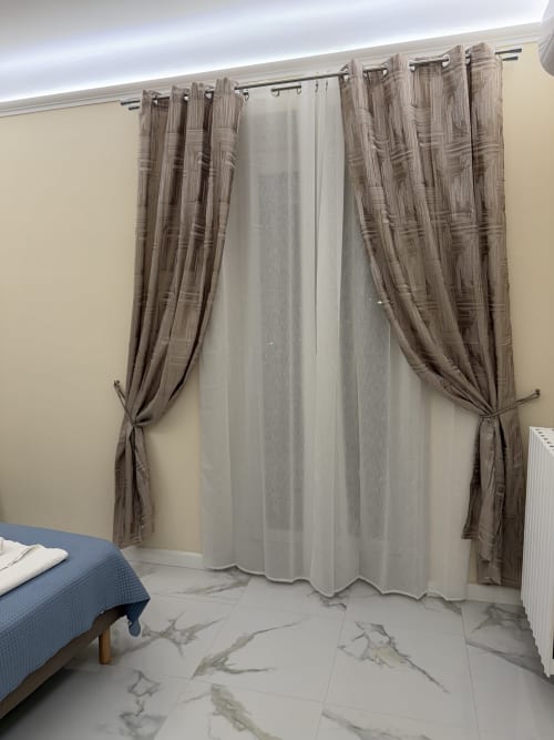 Camera da letto in stile moderno a Zappy Domus B&B a Taranto con pavimenti in marmo, tende decorate e balcone con vista sulla città
