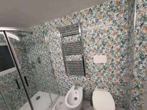 Bagno moderno con carta da parati floreale, doccia, WC, bidet e scaldasalviette riscaldato presso Zappy Domus B&B, Taranto