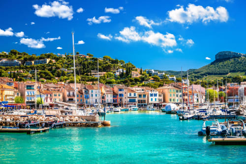 Colorful Mediterranean harbor with boats and hillside buildings in French coastal village