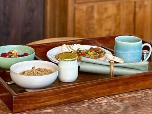 Elegant breakfast tray at Villa Annette B&B with cereal, toast, yogurt, fresh fruit and tea in rustic French setting
