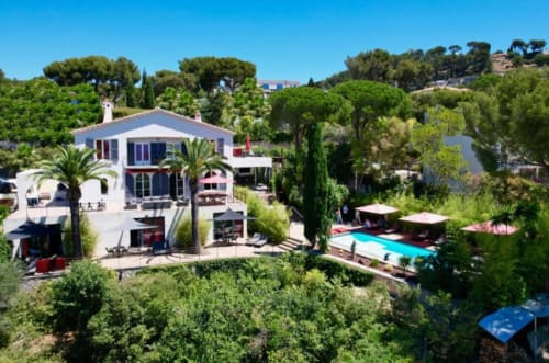 Villa Annette B&B in France: luxury villa with white architecture, pool, palm trees, and Mediterranean gardens on hillside.