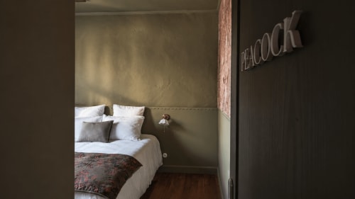 Cozy bedroom at La Maison 1903 B&B in Trévou-Tréguignec with white bedding, decorative pillows, and modern beige wall