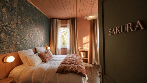 Cozy bedroom at La Maison 1903 B&B in Trévou-Tréguignec with warm wood tones and patterned wallpaper