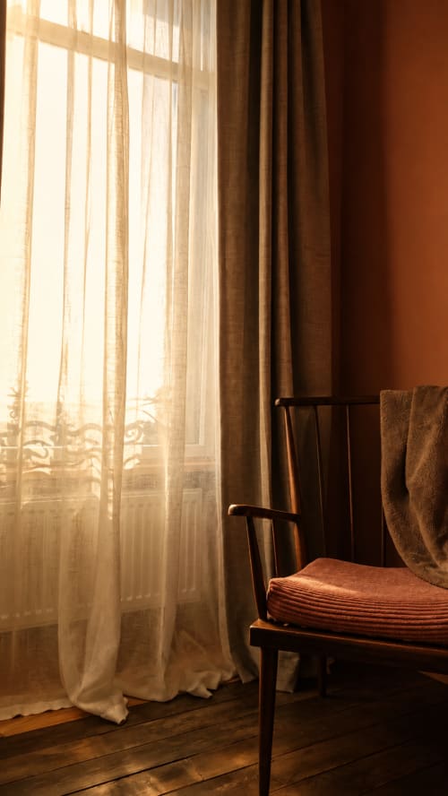 Sunlit bedroom window with sheer curtains at La Maison 1903 B&B in Trévou-Tréguignec