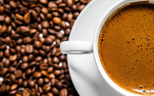Espresso appena preparato con crema in tazza bianca e chicchi di caffè presso l'Hotel Green Poggio Regillo, Frascati