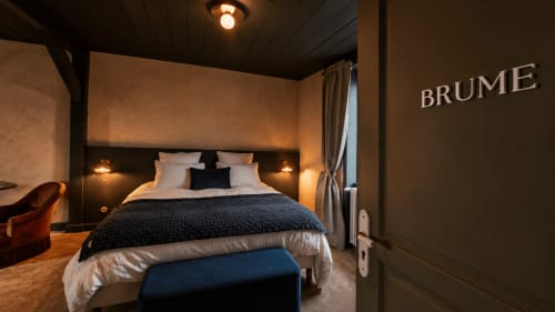 Luxurious bedroom at La Maison 1903 in Trévou-Tréguignec with queen bed, mood lighting, and modern furnishings.