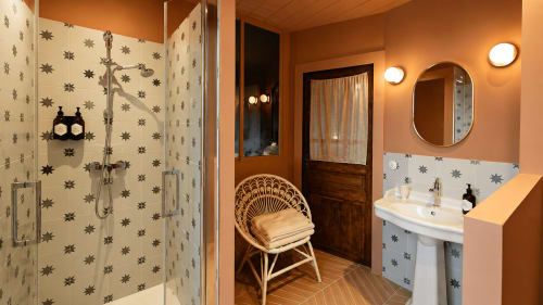 Elegant bathroom at La Maison 1903 B&B in Trévou-Tréguignec with star-patterned tiles, warm lighting, and vintage décor