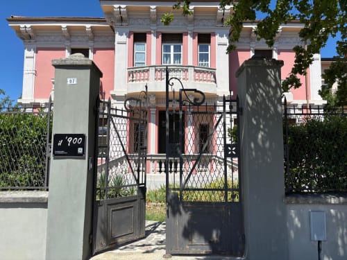 Ingresso della guest house Il 900 ad Avezzano, Italia - facciata neoclassica rosa e bianca con cancellata in ferro battuto nero