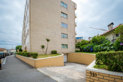 EcoHost-Wohngebäude in Senhora da Hora, Porto mit Backsteinfassade, landschaftlich gestalteter Innenhof und Parkplatz