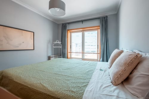 Modernes Schlafzimmer mit Stadtblick im EcoHost OceanSide Apartment in Matosinhos, Bett mit Kissen mit Meerblick