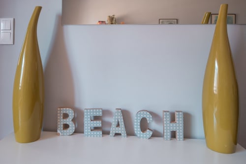 Strandthematisierte Apartmentdekoration mit goldenen Vasen und türkisfarbenen Buchstaben BEACH im EcoHost Oceanside in Matosinhos