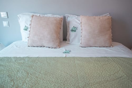 Ordentlich gemachtes Bett mit weißen Kissen und rosa Polstern im Meeresblick-Apartment von EcoHost in Matosinhos