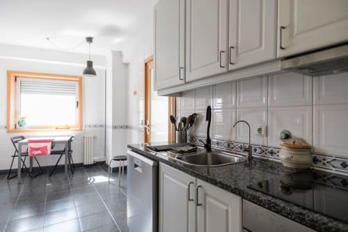 Moderne Küche mit weißen Schränken, schwarzer Granitarbeitsplatte, Edelstahlgeräten im Apartment Gaia Beach&Golf, Arcozelo