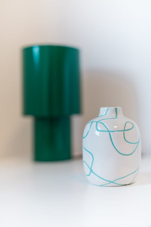 Umweltfreundliche Toilettenartikel bei EcoHost Gaia Beach - weiße Flasche mit türkisem Design und grüner Behälter