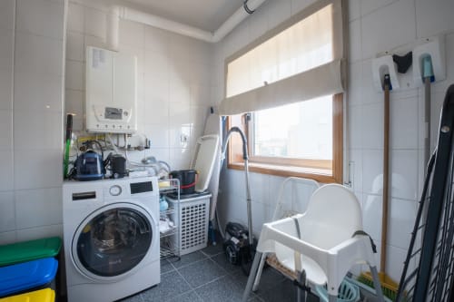 Waschküche mit Waschmaschine, Trockner, Bügelbrett und Reinigungsmitteln im EcoHost-Apartment Gaia Beach&Golf