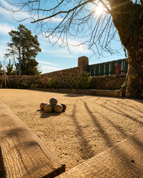 Cour rustique de la Maison 1903 B&B à Trévou-Tréguignec avec murs de pierre et sphères décoratives