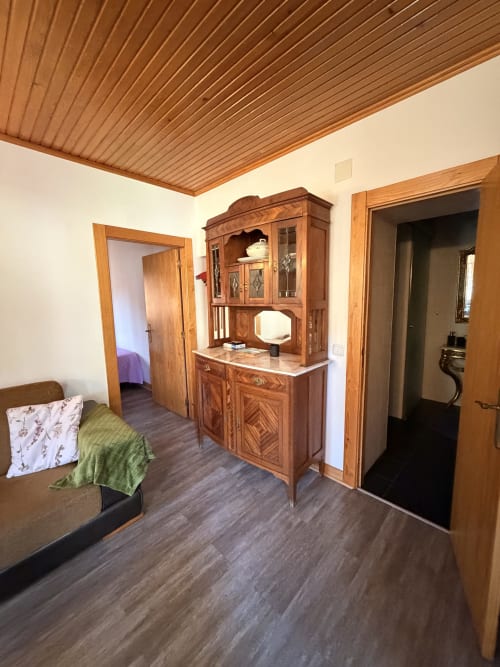 Interior rústico de quarto na Casa Relva da Mó com mobiliário tradicional, piso escuro e teto de madeira