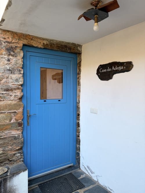 Porta azul da entrada de Casa da Adega, cottage em Casas do Sinhel, Relva da Mó, com arcaria em pedra e vista para montanhas