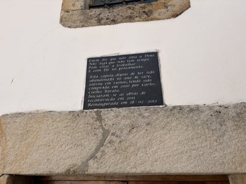 Placa comemorativa portuguesa em parede de pedra na vila Casas do Sinhel em Roda Fundeira