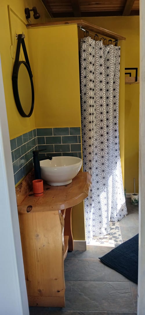 Salle de bain moderne du Chalet Eléonore au Domaine de Jade, Saint-André, aux murs jaunes, vasque design et douche géométrique