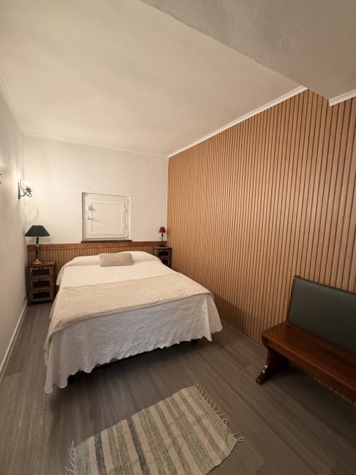 Quarto da villa Casa das Oliveiras em Alvares com cama, mesas-de-cabeceira em madeira e cortinas rolô verticais bege