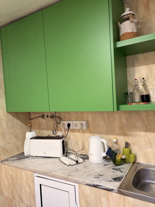 Canto compacto da cozinha da vila Casa das Oliveiras em Casas do Sinhel com armários verdes e bancada em mármore