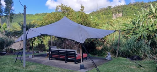 Chapiteau bleu de style tendu avec bancs noirs dans le jardin luxuriant du Domaine de Jade, Saint-André Réunion
