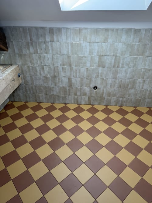 Salle de bain moderne aux carreaux géométriques losange marron et crème, murs en carrelage subway vert pâle à La Grange Aux Etangs