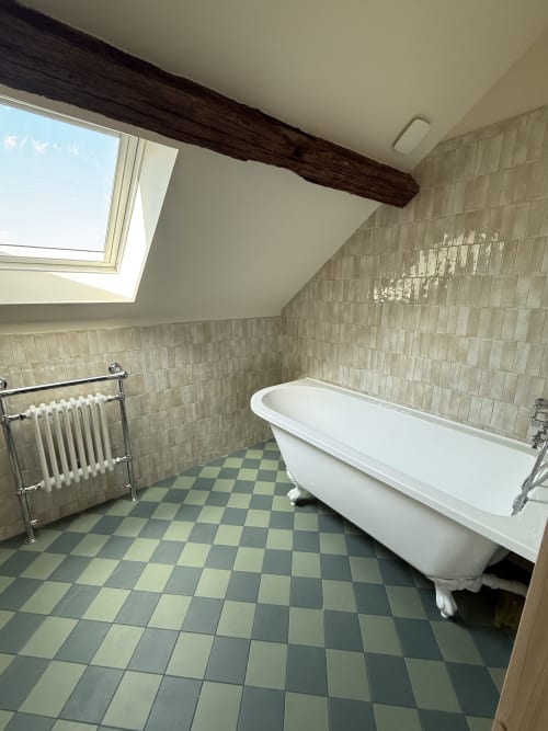 Salle de bain luxueuse sous les combles à La Grange Aux Etangs avec baignoire îlot, sèche-serviettes chauffant et carrelage à carreaux