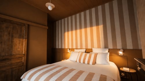 Chambre cosy de La Maison 1903 à Trévou-Tréguignec avec literie rayée et éclairage chaleureux