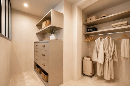 Luxurious walk-in closet in Suite Cézanne at Les Suites de Montigny, Aix-en-Provence, with wooden shelving, dresser, robes on