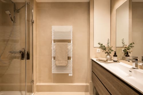Modern bathroom in Suite Cezanne at Les Suites de Montigny, Aix-en-Provence, with white heated towel rack, wooden vanity, and