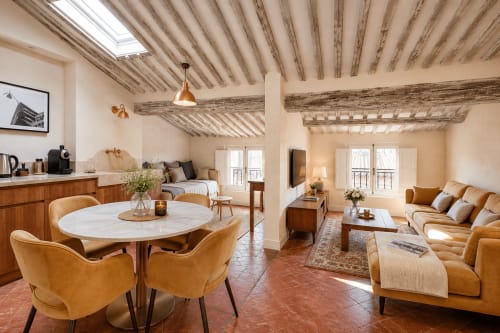 Suite Cézanne at Les Suites de Montigny in Aix-en-Provence featuring exposed wooden beams, open-plan living with dining area,