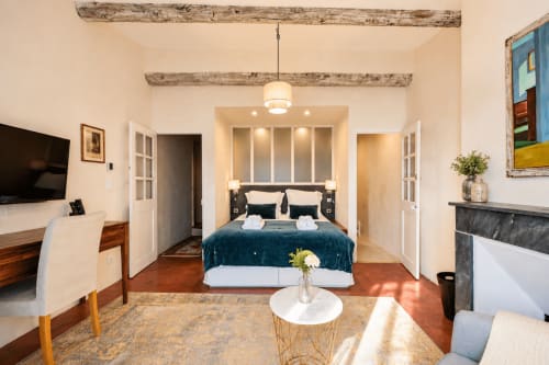 Suite Cezanne bedroom at Les Suites de Montigny, Aix-en-Provence, with king bed, fireplace, and garden view