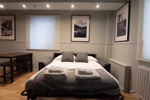 Superior Quadruple Room at La Borda del Gato Rafa hotel in Vielha featuring sofa bed, city views, and modern amenities