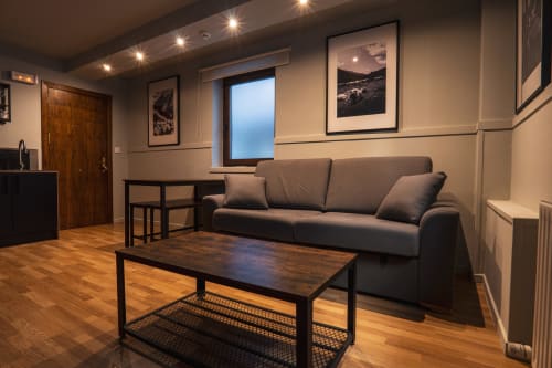 Superior Quadruple Room at La Borda del Gato Rafa in Vielha with sofa, coffee table, and city views from balcony