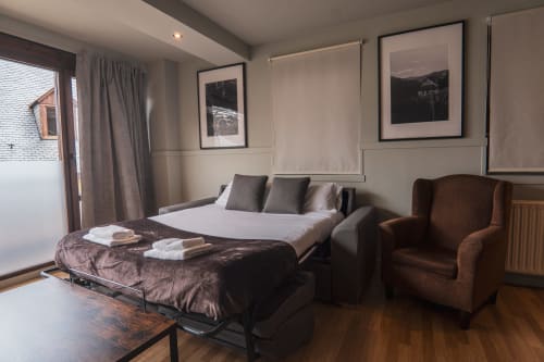 Superior Quadruple Room at La Borda del Gato Rafa in Vielha with sofa bed, armchair, and city views