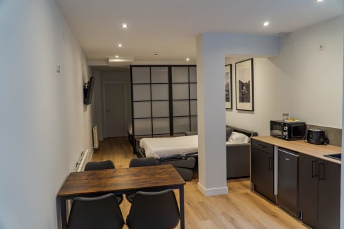 Premium Quadruple Room at La Borda del Gato Rafa in Vielha with dining area, kitchenette, and bedroom with black-framed
