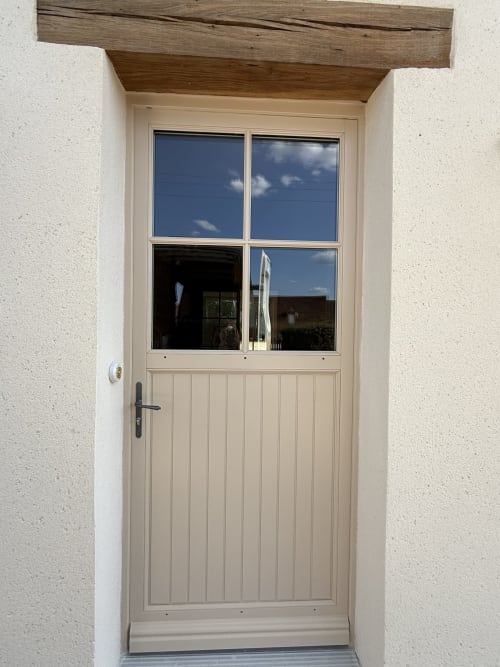 Porte d'entrée crème avec fenêtre à quatre carreaux à La Grange Aux Etangs, Sennely, mettant en valeur la campagne française
