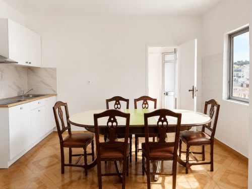 Sala de jantar luminosa com mesa redonda e cadeiras de madeira no Apartamento Casa da Mãe em Villas Simone Porto Santo, Portugal