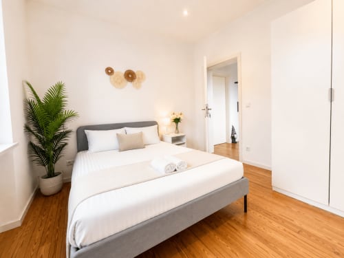 Chambre moderne de la villa Mattbnb Metz avec lit queen-size, plante en pot et accès à la salle de bain privée