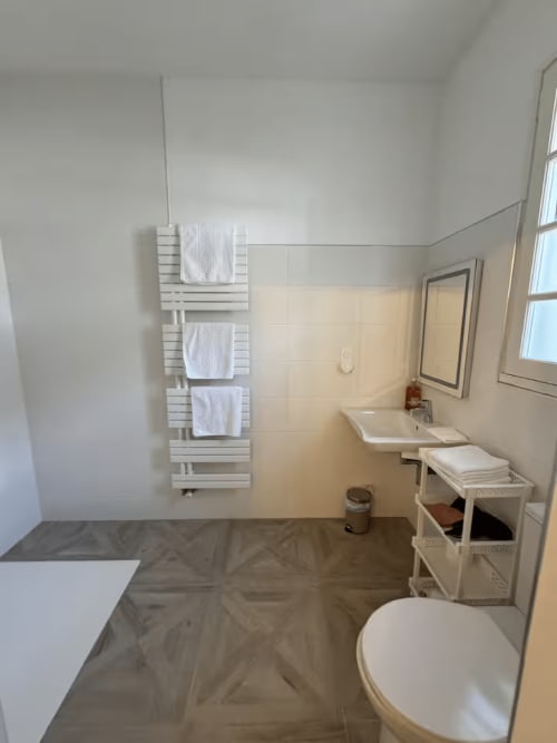 Modernes Badezimmer mit WC, Waschbecken, beheiztem Handtuchhalter und Regalen in Domaine de Bize Mirepoix