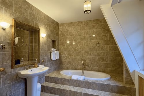 Luxuriöses Badezimmer mit Ankleideraum zum Hauptschlafzimmer des Schloss Domaine de Bize in Mirepoix, mit Fliesen und Badewanne