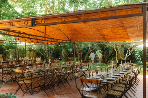 Espace de restauration en plein air à l'Auberge du Parc de Correns avec pergola bois, tables dressées et arbres matures